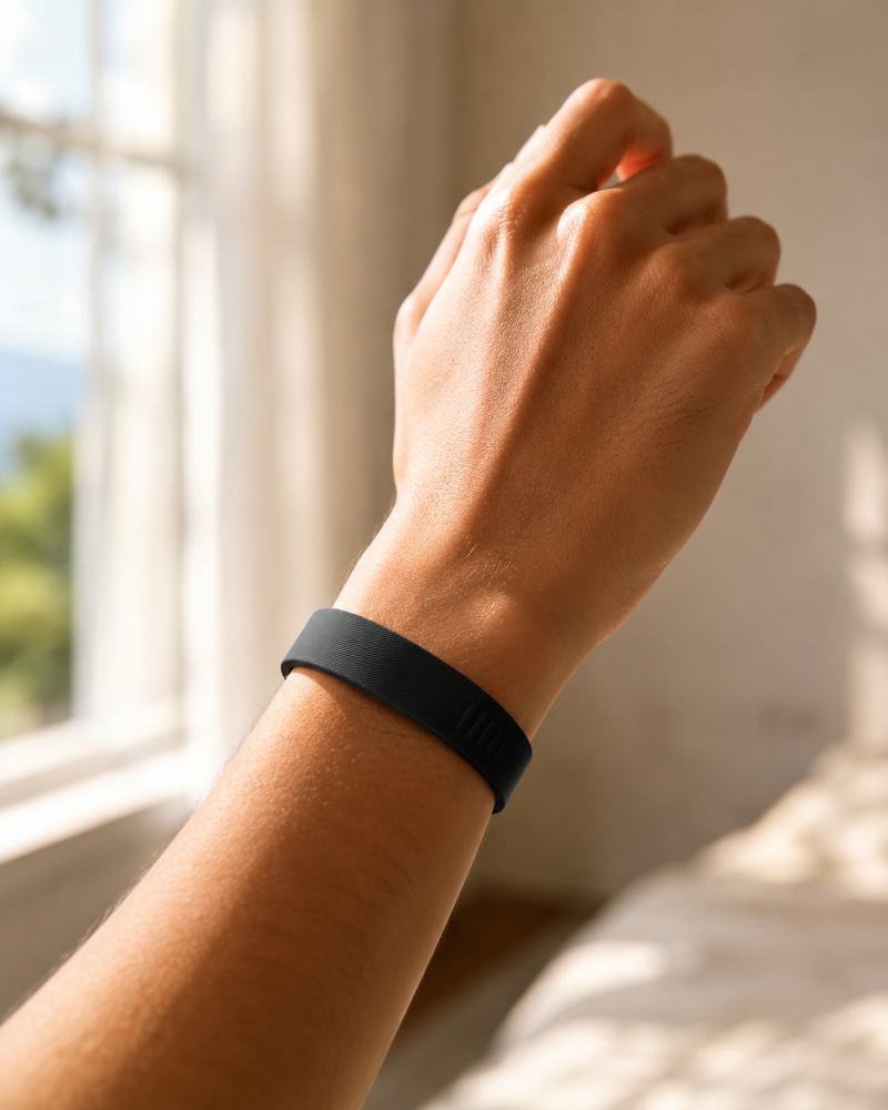 Person wearing the Deep Pulse Band wristband, morning light, real bedroom setting